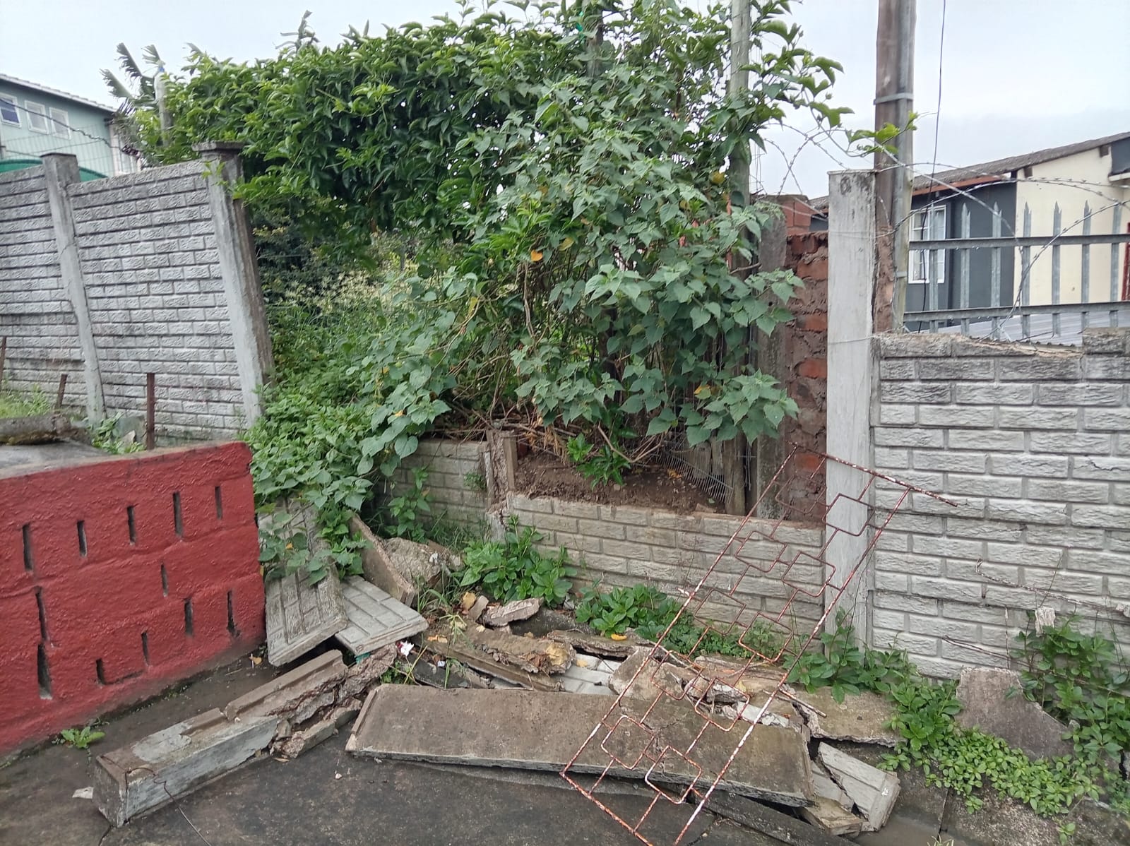 Collapsed boundary wall before Africa Works rebuilt it