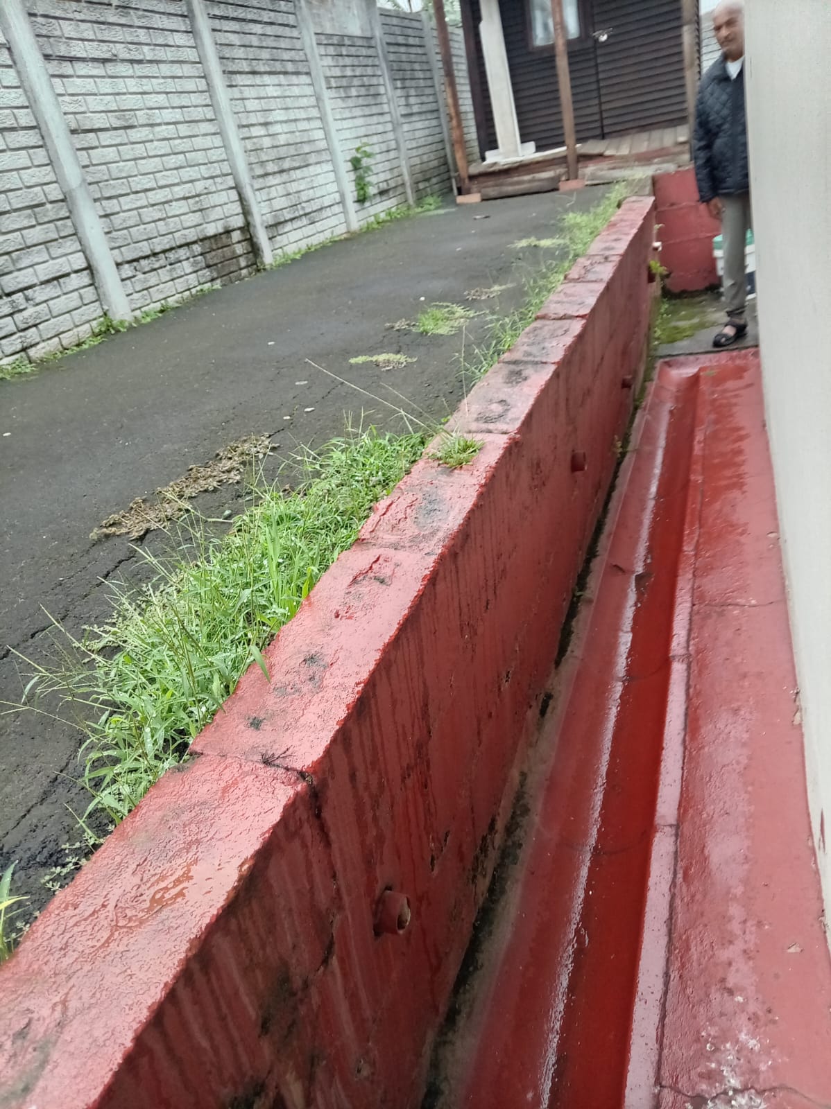 Damaged boundary wall before Africa Works rebuilt it